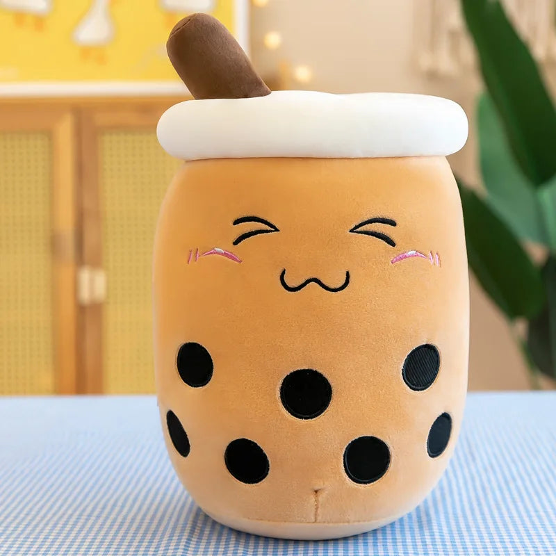 A brown bubble tea drink with a blushing face, squinting eyes, pink cheeks, a coy smile, and seven black circles of boba