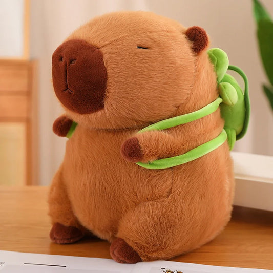 Image depicting a cute brown capybara plush with a green tortoise backpack on his back.