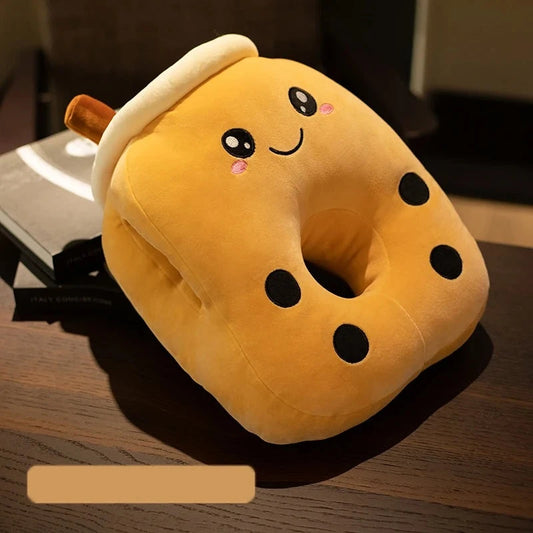 A brownish boba milk tea pillow cushion with a hole in the middle for lying flat on your face, with four black dots representing tapioca, a brown straw sticking out of the top, a white rim representing the top of the cup and foam, and two side holes to put your hands while sleeping.