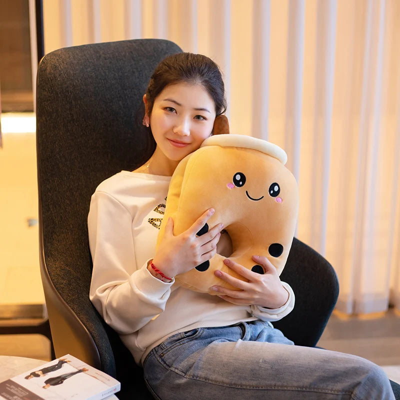 The image shows a girl sitting on a modern looking chair wearing jeans holding a smiling brown sugar boba tea center-hole pillow.