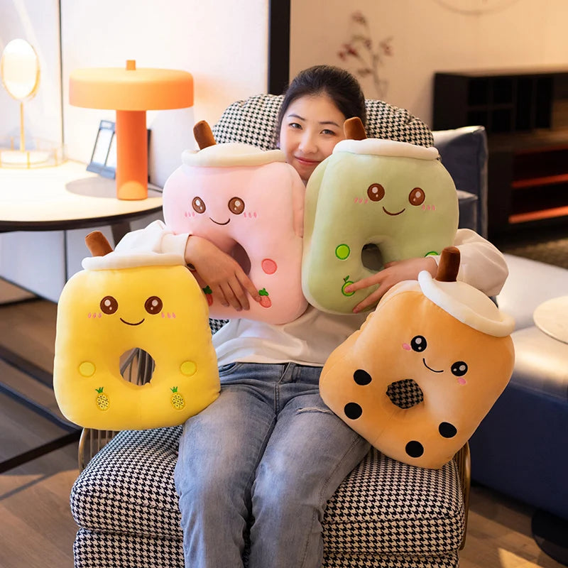 A girl sitting on a recliner with four different smiling bubble tea center hole pillows including from left to right pineapple, strawberry, apple, and brown sugar.