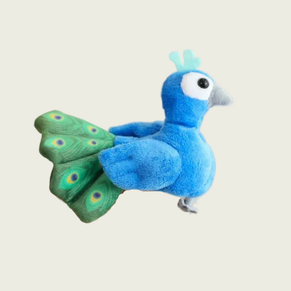 Blue and green plush peacock toy held on a finger against a neutral background