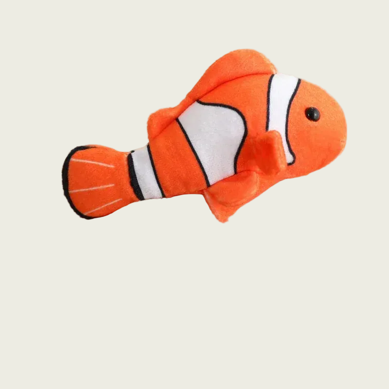 Plush clownfish toy on a finger against a beige background