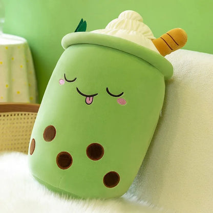 An image of a matcha cream boba plushie with five brown bubble tapiocas, a sleeping face with tongue sticking out, and cream and a brown straw at top