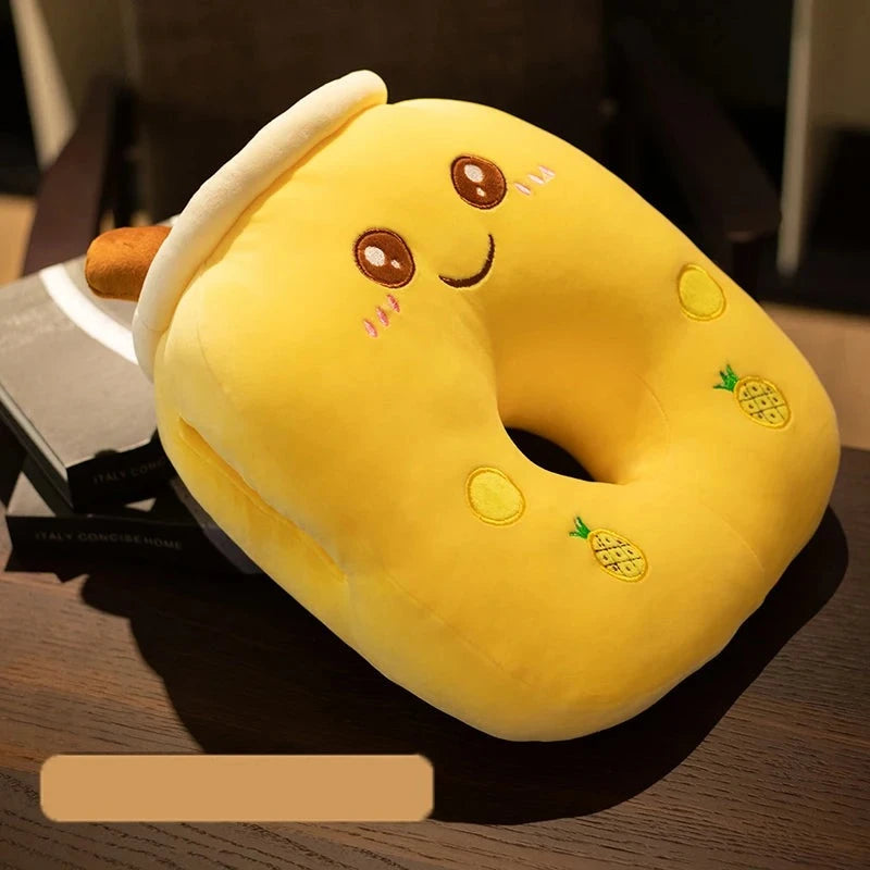 A yellow bubble tea pillow with a smiley face, two pineapples, two small yellow circles, and a brown straw. The pillow has a center hole going through the plushie so someone can lie flat face down and their nose, mouth, and eyes won't be obstructed but rather open for easy breathing and comfortable sleeping.